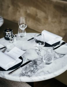 tavolo marmo apparecchiato con piatti neri